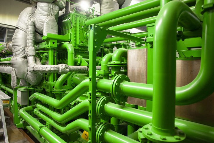 Eine beeindruckende Anordnung von grünen Industrierohren und Ventilen, dicht an dicht montiert, deutet auf die komplexe Infrastruktur innerhalb eines technischen Betriebs hin, wie zum Beispiel ein Kraftwerk oder eine chemische Verarbeitungsanlage.