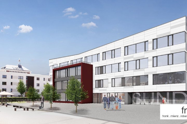 Moderne Architektur des Schulzentrum am Sund mit weißer Fassade und auffälligen roten Akzenten, belebt durch begrünte Außenbereiche und einen sonnigen, klaren Himmel.