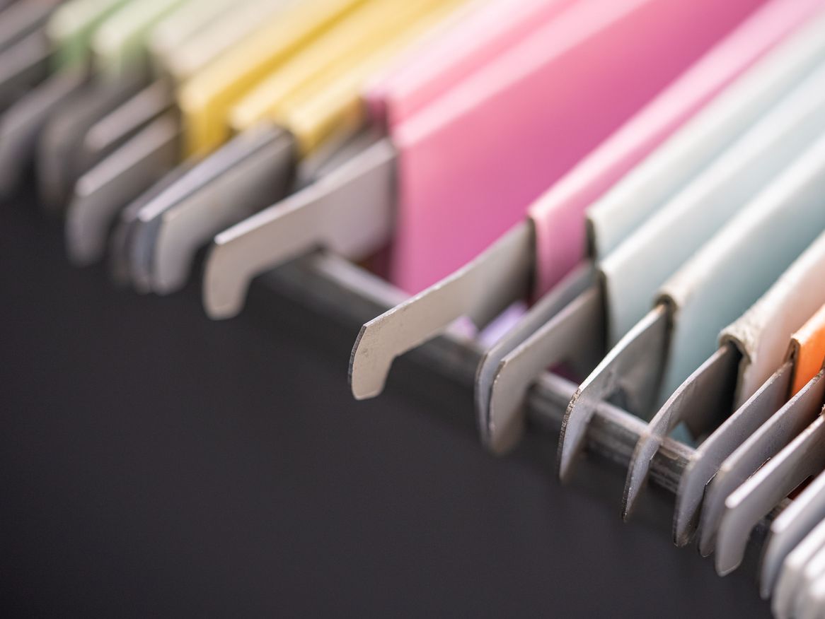 Bei dem zweiten Bild handelt es sich um eine Nahaufnahme einer Reihe von gebundenen Notizbüchern in verschiedenen Farben auf einer dunklen Unterlage, was auf Organisation und die Vielfalt an Optionen für persönliche Notizen oder kreative Arbeiten hinweist.